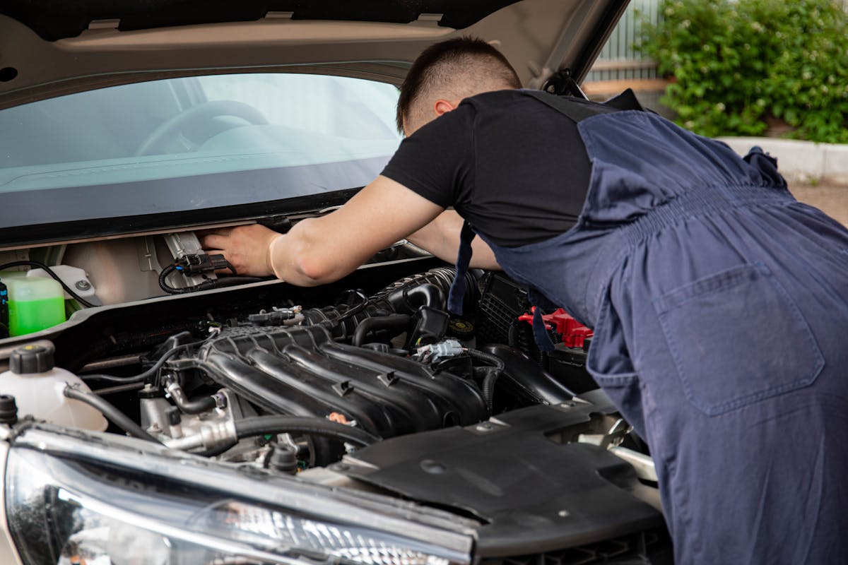 Man in Black Crew Neck T Shirt Fixing a Car