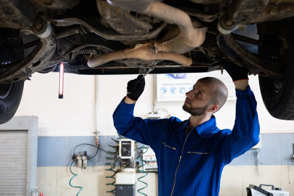 Man in Blue Coverall Fixing a Vehicle