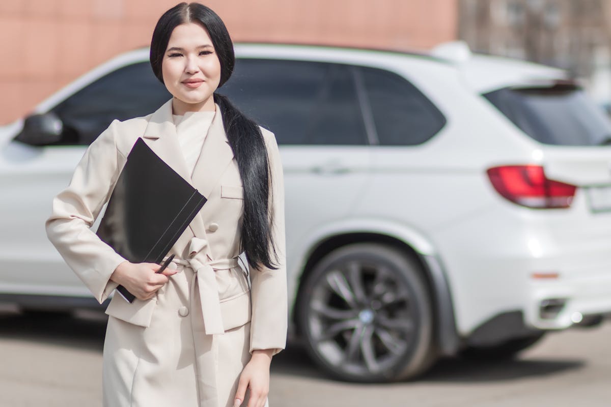 Woman in Beige Corporate Clothes Holding Black Folder