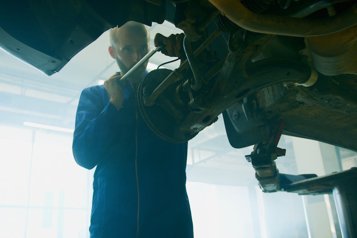 A Mechanic Holding a Tool Near and a Vehicle