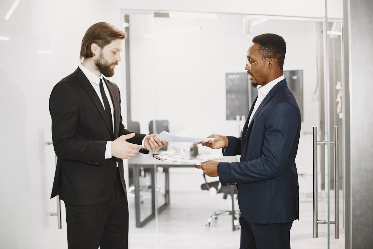 Men in Office Exchanging Documents