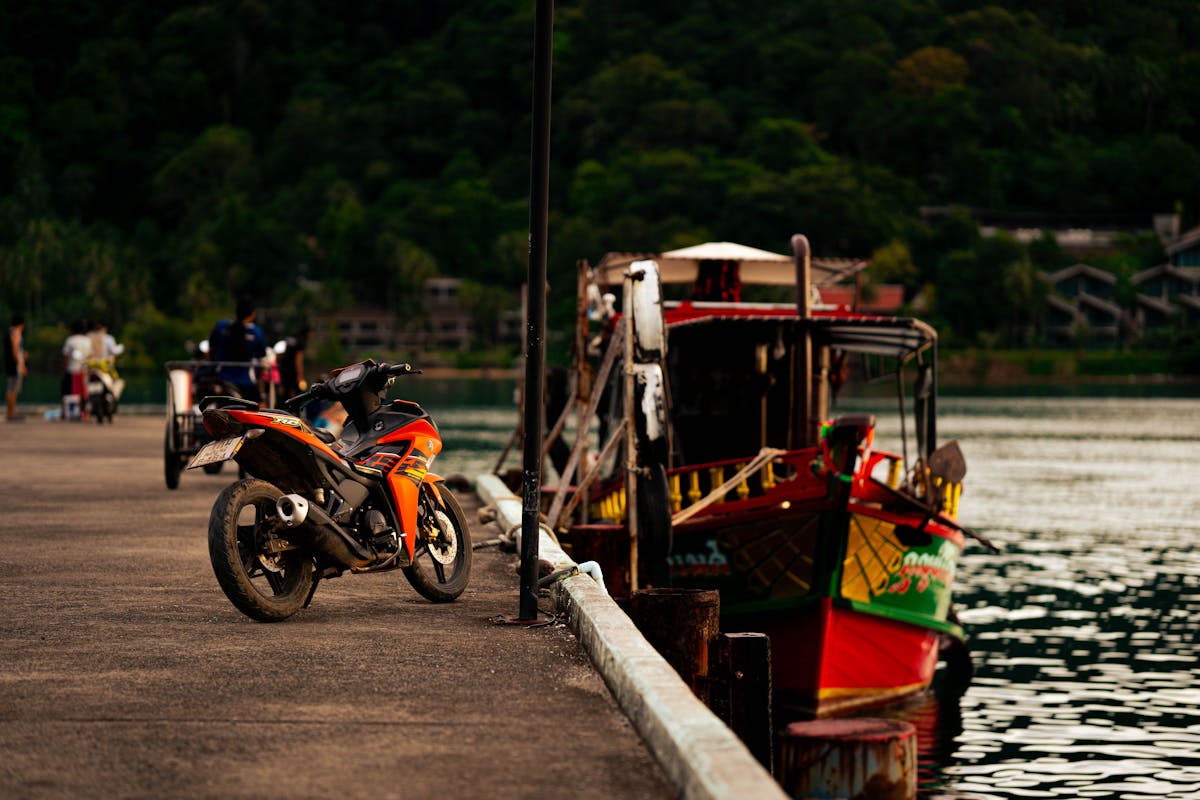 Motorcycle and Traditional Boat at Thai Pier